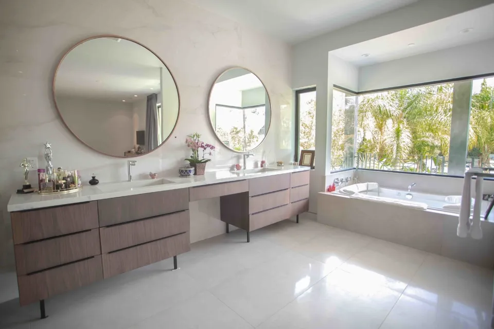 Bathroom vanity with round mirrors and a freestanding tub